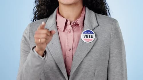 Woman in studio with campaign to vote, badge and hand showing choice for government support
