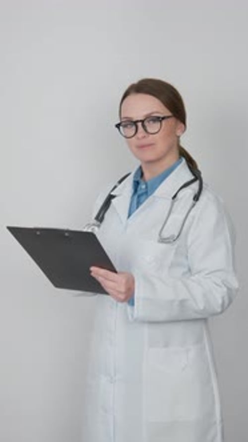 Smiling Female Doctor Holding a Clipboard