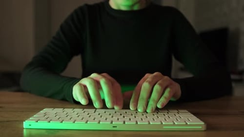 Office worker working in a dark room. Working night. Late night work. Computer hacker typing code.