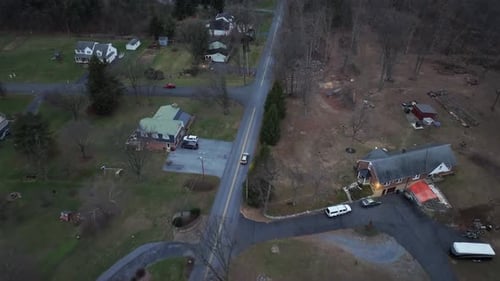 Car turning into american suburb neighborhood during cloudy winter day in USA. Forest landscape with
