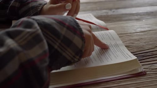 Dedo femenino siguiendo un pasaje de la Sagrada Escritura de la Biblia que reflexiona sobre la palabra de Dios