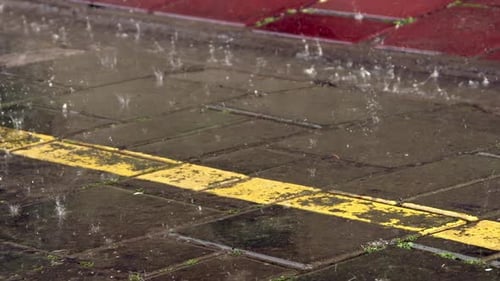 Regenwassertropfen, die auf quadratische Pflastersteine fallen