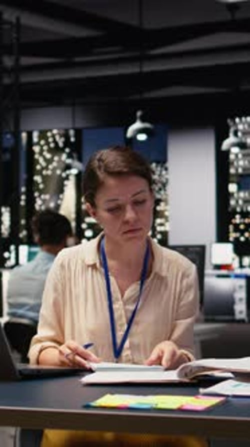 Vertical Video Woman Employee in Office Completing Spreadsheets on Laptop