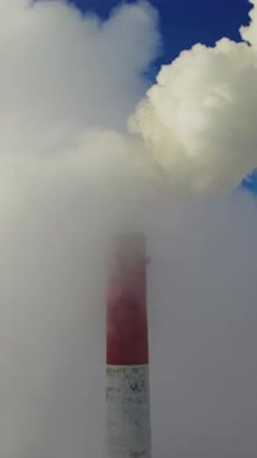 Smokestack Emissions Against Blue Sky in Vertical Video