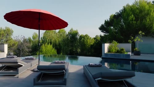 Slow dolly past sunlounger at a private pool in the garden of a villa in St Gely du Fresc