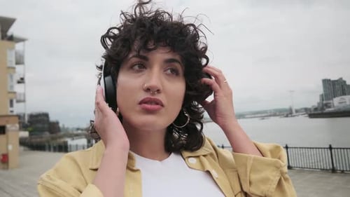 Attractive Woman Listens to Music With Headphones Outdoors