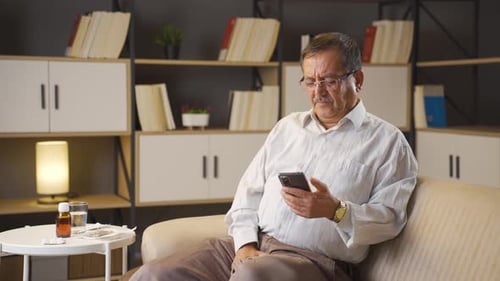 Senior Man Using Phone and Experiencing Pain