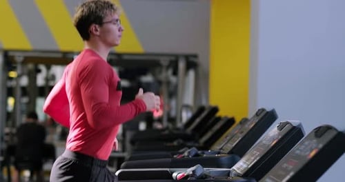 Muscular Young Man Training at Gym Guy Runs on Treadmill Confident Bodybuilder Working His Body in