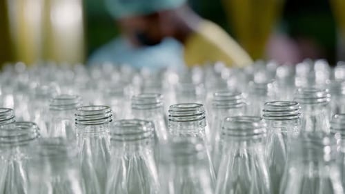 Empty Glass Bottles on a Conveyor Indicate a Modern Distillery's Alcoholic Beverage Production and