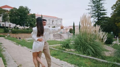 Recién casados emocionados bailando en el callejón. Pareja romántica activa sincronizando movimientos de baile en Botanical...