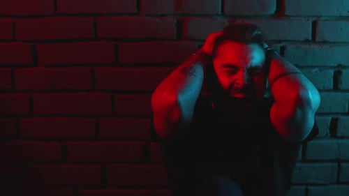 Trauriger Mann packt den Kopf und schreit emotional