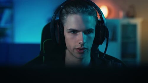 Young Man with Headset Looking at Computer Screen