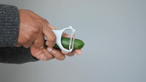 Peeling a Fresh Cucumber in a Clean Kitchen Setting