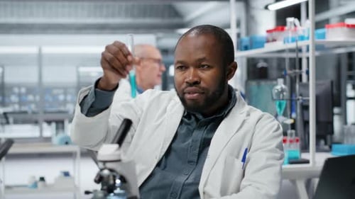 Un biochimiste joyeux en laboratoire évalue des solutions composées pour une nouvelle formulation de médicaments