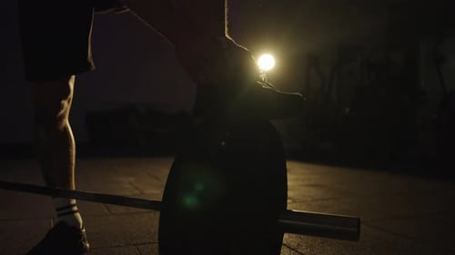 Preparing for strength training in a gym setting during evening hours