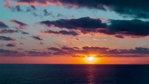 Sunset sea timelapse. Sun goes down the horizon. Nice warm colors in the sky and the clouds. Tropica