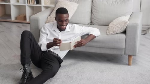 Young Man Reading a Book at Home