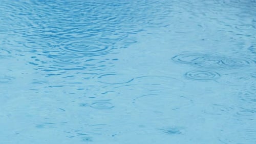 Gouttes de pluie tombant sur la surface lisse de la piscine.