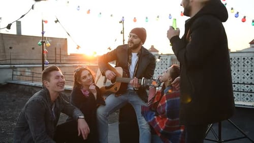 Friends Gather with Guitar Music on City Rooftop