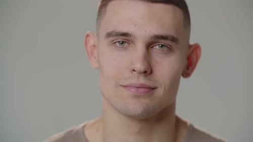 The Young Man Looks Up and Starts Smiling While Looking Straight Into the Camera Portrait Shot of a