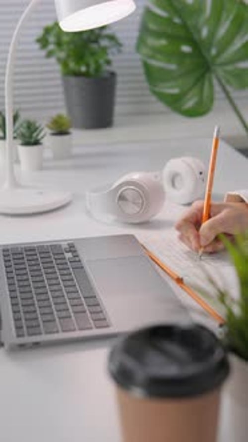In This Modern Home Office Setup There is a Laptop Headphones and Coffee Placed on a Desk Creating a