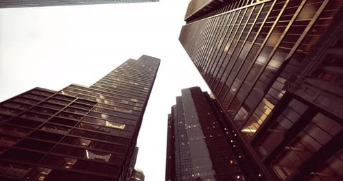 Paisaje urbano que muestra edificios imponentes bajo un cielo nublado al anochecer