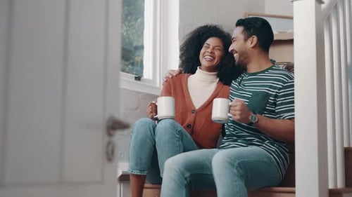 Happy Couple Laughing Together at Home on Stairs