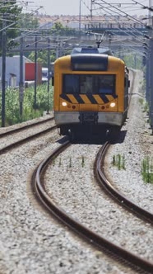 Yellow Commuter Train Traveling on Curved Railway Tracks