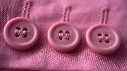 Botones rosas sobre tela rosa