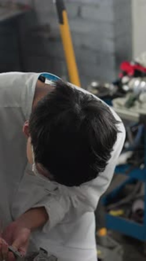 Overhead View of Student Recording Measurements in Automotive Workshop