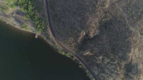 AERIAL - Spiral Shot of Desert Road Near Lake