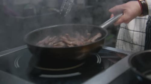 Chef Cooking Meat in Commercial Kitchen