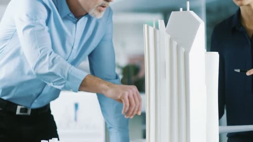 Male Senior Engineer and Female Architectural Designer Work on a Building Model Design for the Urba