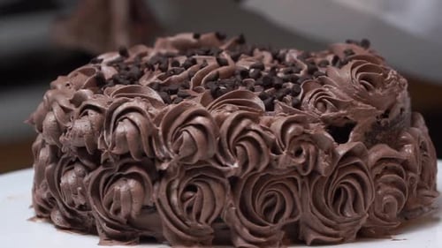 Gâteau au chocolat sur table tournante avec glaçage à motif floral.