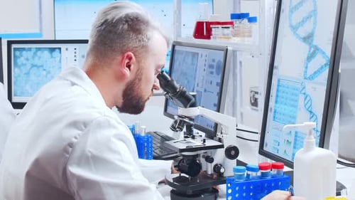 Scientist Viewing Sample Under Microscope in Bright Lab