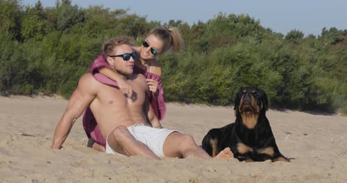 Happy couple and their dog at the beach on vacation