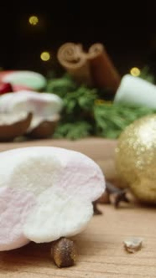 Vertical video. A table with Christmas decorations, marshmallows and a ginger cane in a mug
