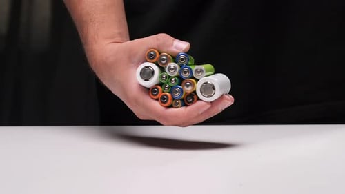 Hand Holds Colorful AA and AAA Batteries