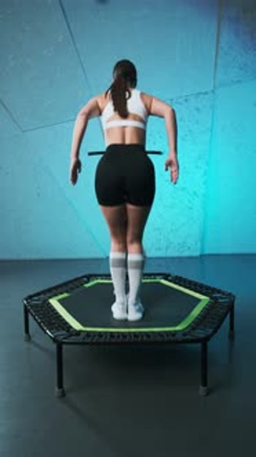 Woman Exercising on Trampoline in Gym Setting
