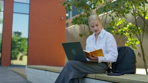 Young Woman Working on Laptop Outdoors Urban Setting