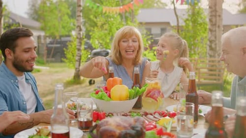 Big Family Garden Party Celebration, Gathered Together at the Table Relatives and Friends are Eatin