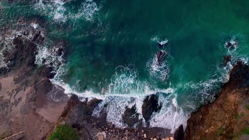 Luftbild von oben nach unten auf die tosenden und schäumenden Meereswellen am leeren tropischen Strand mit Stopp