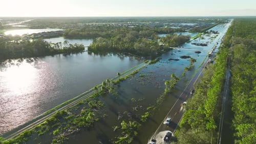 Flooded American Street with Moving Vehicles and Surrounded with Water Houses in Florida Residential