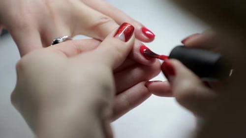 Applying Shiny Red Nail Polish in a Salon
