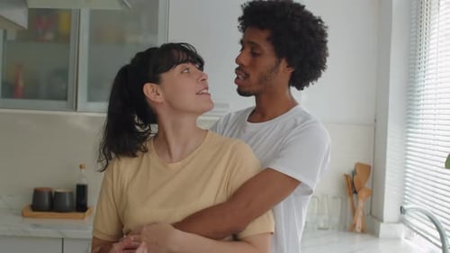 Loving Couple Embracing Tenderly in Modern Kitchen