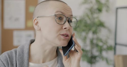 Confident Businesswoman Speaking on Mobile Phone Working in Office Alone