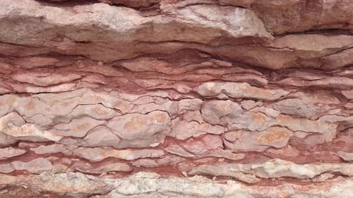 The Camera Moves Smoothly Along the Wavy and Textured Pink Rock Formation Closeup