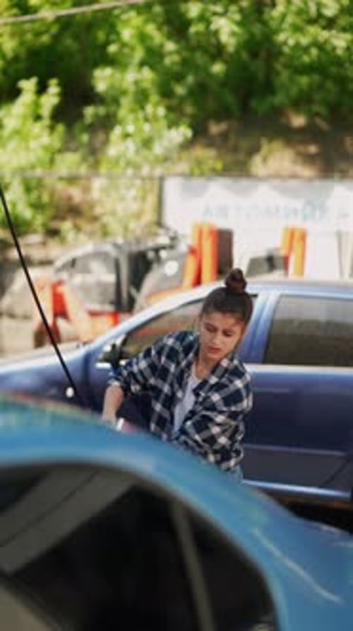 Using a Highpressure Water Gun for Cleaning the Car Undergoes a Thorough Wash