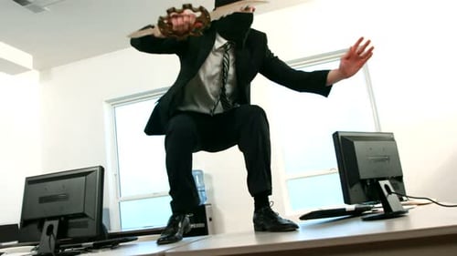 Man in Suit Leaping on Desk with Knife