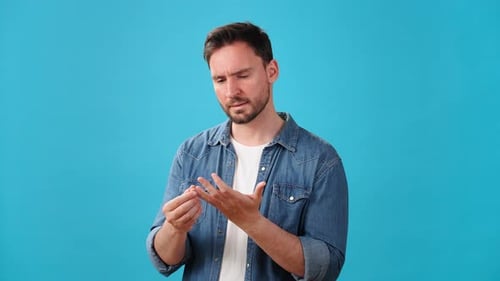 Nachdenklicher Mann spreizt die Finger, zählt Dinge oder kauft ein